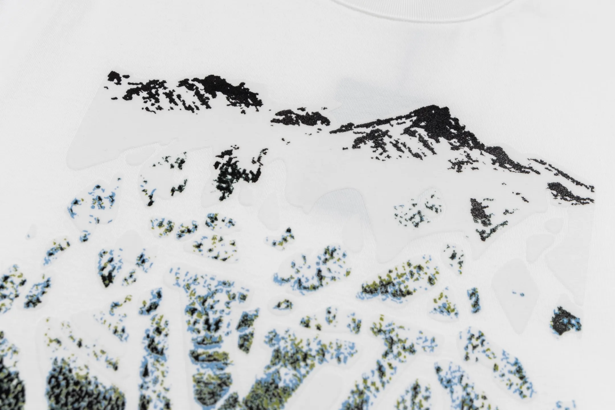 🅿️300 1v SKI ski series velvet jacquard foam short sleeves. The fabric is made of 15S 230g fine cotton plain fabric, and the rib is made of 32S 380g double yarn rib. This T-shirt is made of elegant cotton with a richly textured velvet 1V pattern on the front, depicting rock peaks, snowfields and forest scenes. The crack effect simulates a forest path, and the 1V logo is implicitly embellished in the center. The avant-garde and elegant shape embodies the casual style of winter. The base is made of 15-count combed cotton jersey fabric, with a weight of 230g/㎡, giving it a flexible texture and excellent morphological stability. Short lint impurities are removed through the combing process to ensure the smoothness of the cloth surface and yarn strength. Combined with high-density weaving, the fabric has a delicate and smooth texture, providing an ideal canvas for subsequent complex printing. The surface of the fabric is smooth and delicate, and the texture is tight. The fabric has good softness and comfort, stable breathability, and can keep the body dry. The pattern is realized through overprinting of more than six colors of velvet slurry. In the gradient transition between rock peaks, snowfields and forests, by adjusting the density of velvet powder and the thickness of the slurry, a micro-three-dimensional suede surface drop of 0.2-0.5mm is formed. The snow peak area uses high-reflective velvet pulp to create a cold texture, and the forest part uses dark thick slurry accumulation to simulate vegetation levels. The crack effect uses the slurry blanking technique to tear out a visual channel to the base fabric in the suede matrix. Size:XS-S-M-L